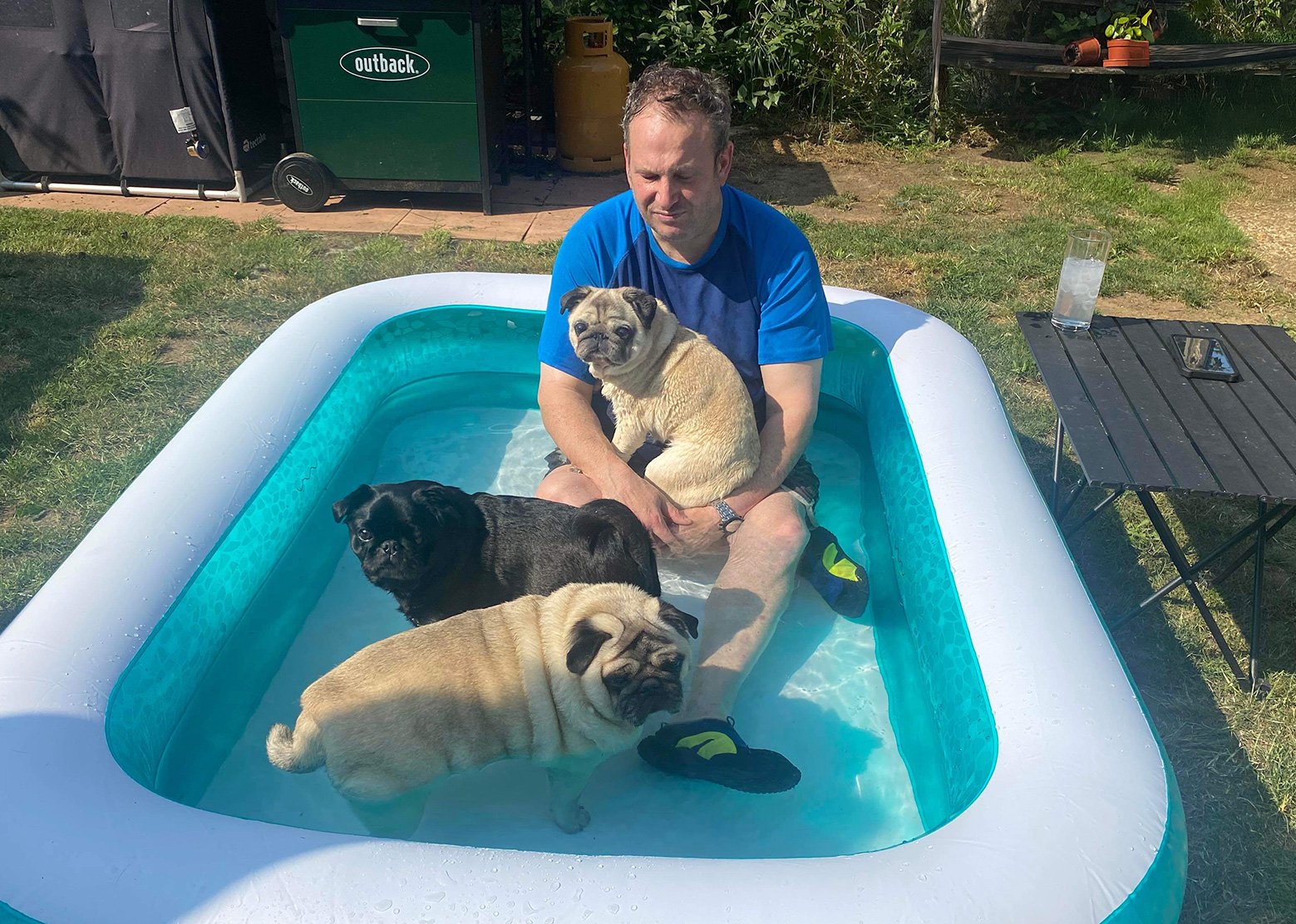 Pug transporter Brian in the garden with his pugs